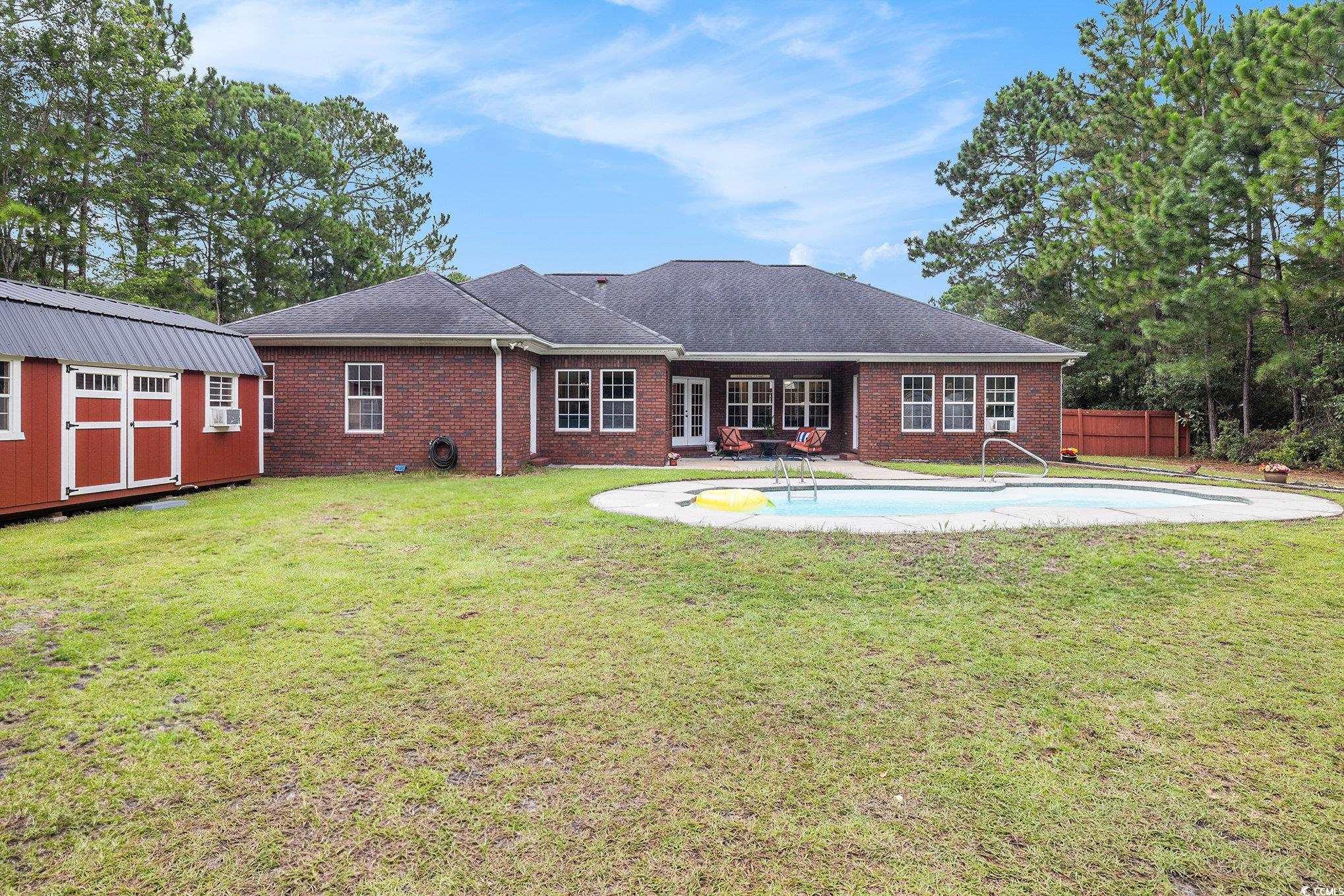 2425 Hunters Trail Myrtle Beach, SC 29588 - Photo 34 of 40 Back of house featuring brick siding, a shed, and a shingled roof
