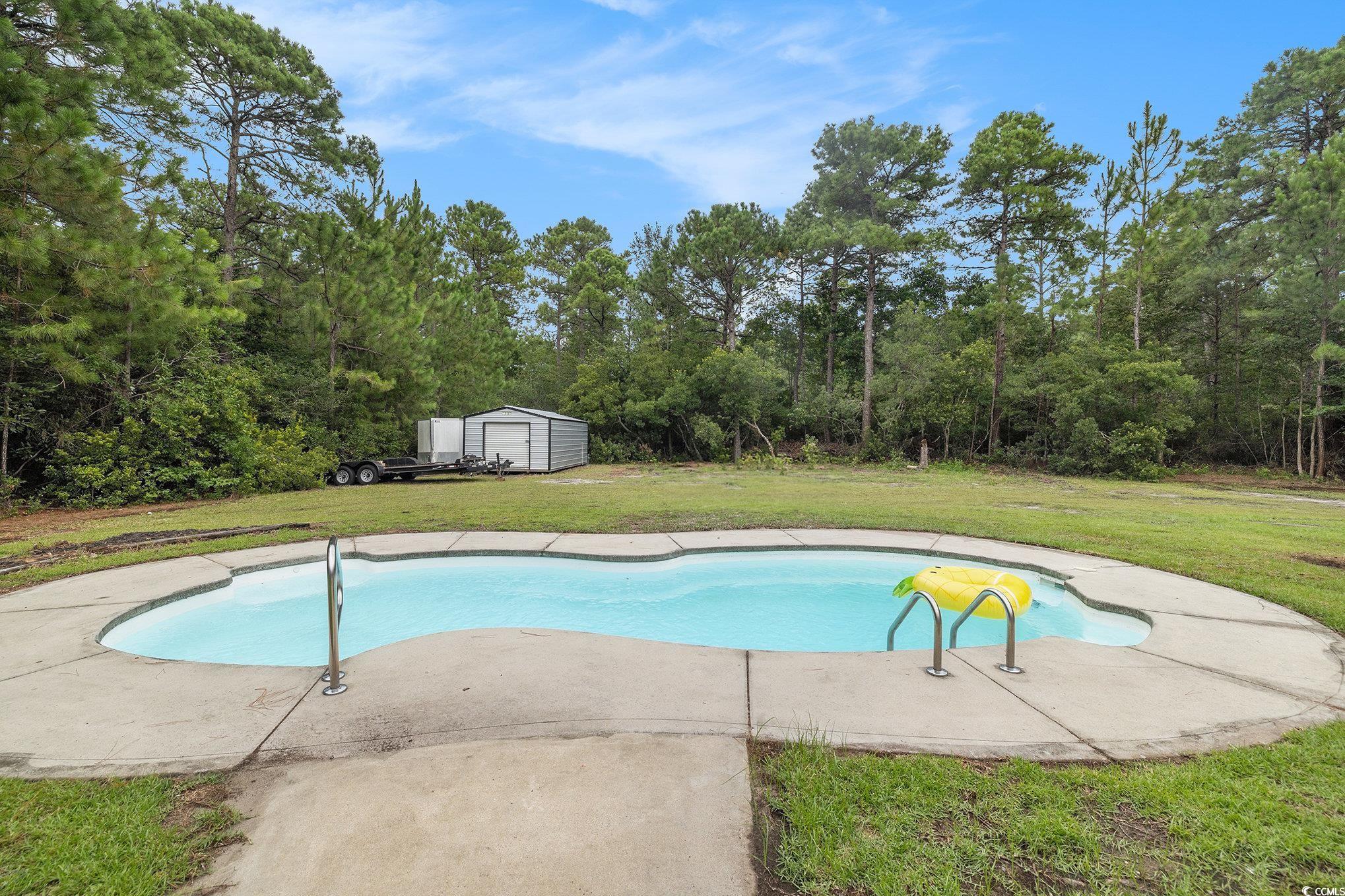 2425 Hunters Trail Myrtle Beach, SC 29588 - Photo 4 of 40 Swimming pool with a yard, a storage unit, and a patio