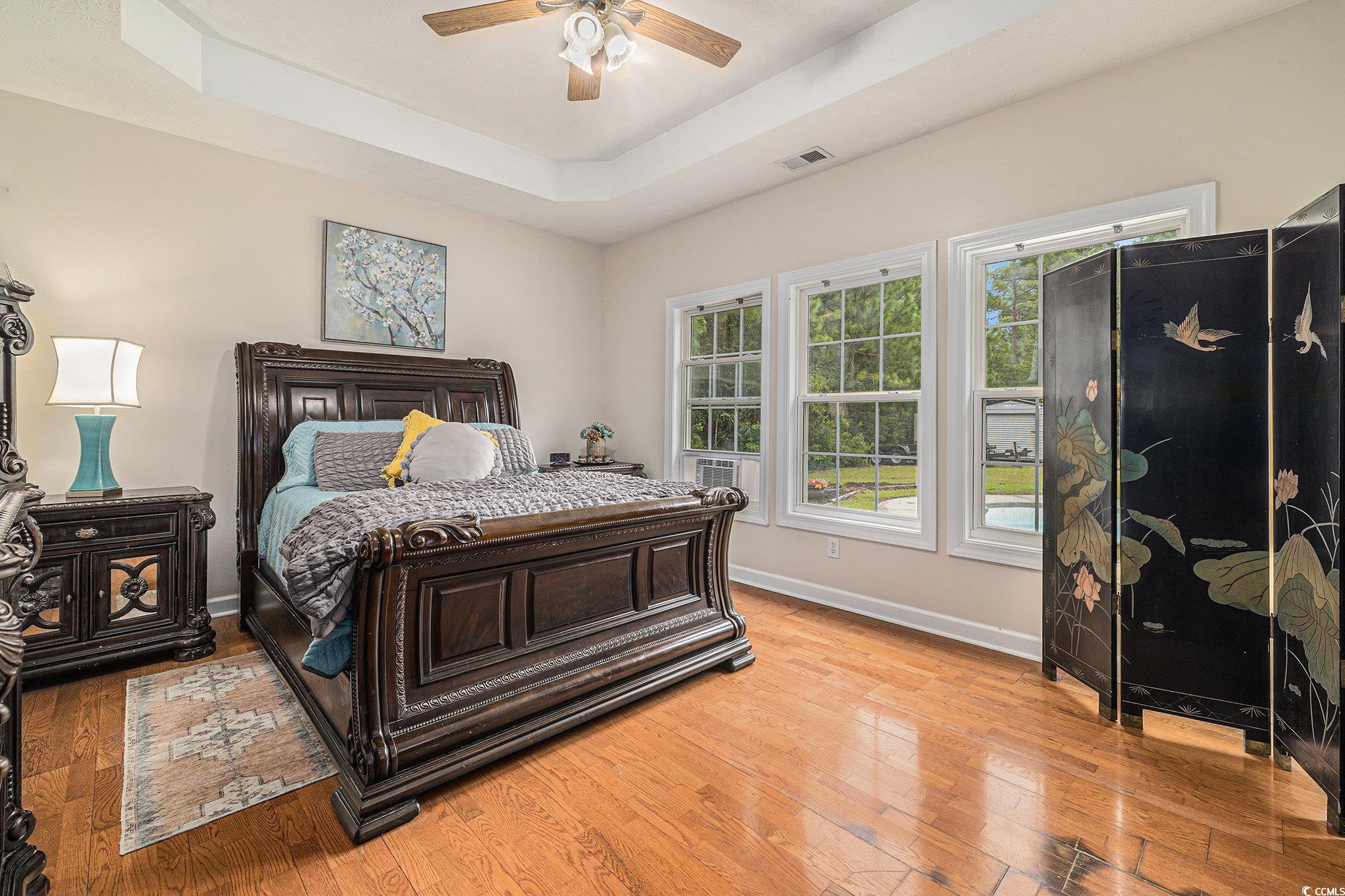 2425 Hunters Trail Myrtle Beach, SC 29588 - Photo 8 of 40 Bedroom with a tray ceiling, light wood-style floors, and ceiling fan