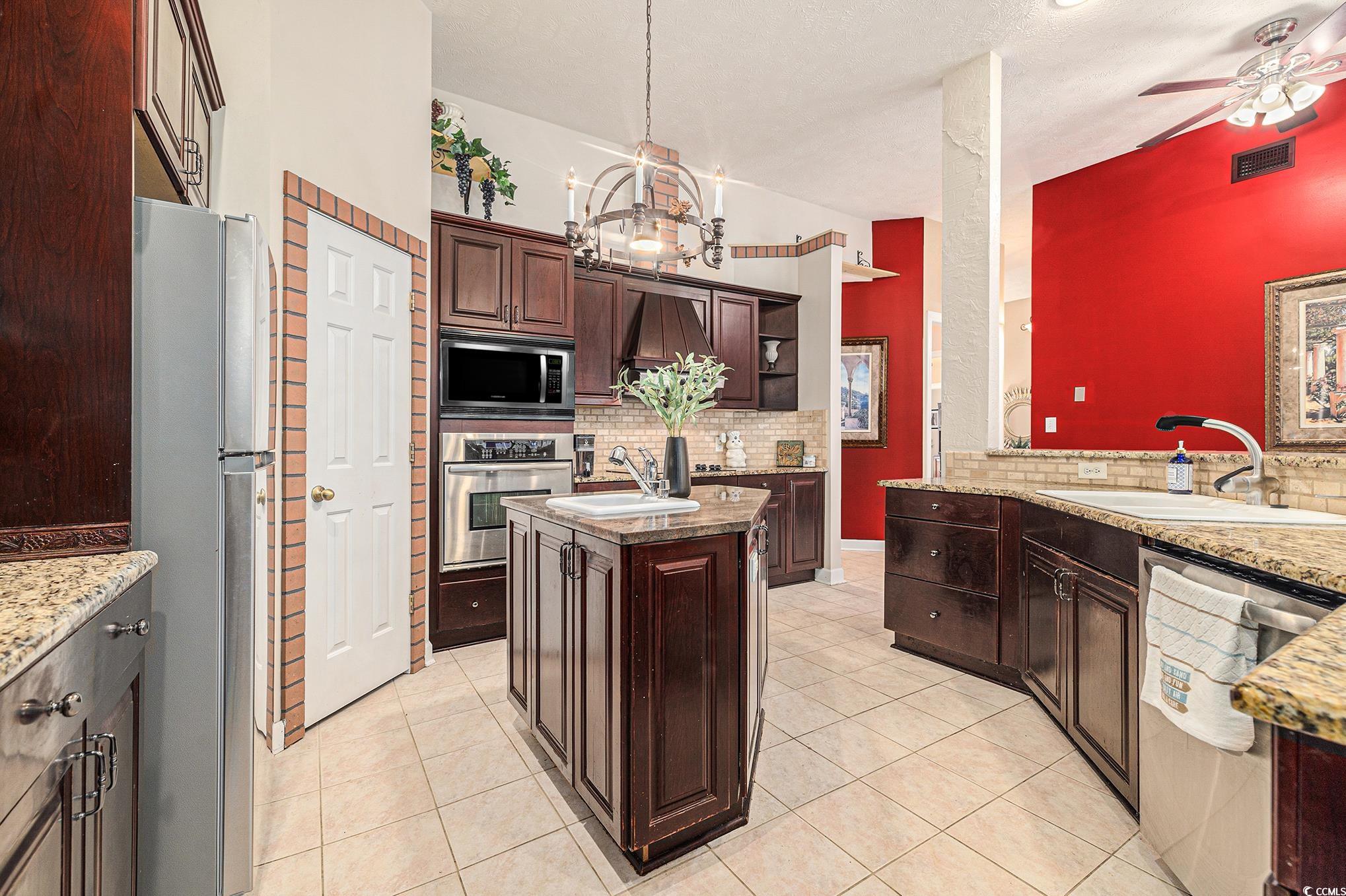 2425 Hunters Trail Myrtle Beach, SC 29588 - Photo 10 of 40 Kitchen with tasteful backsplash, stainless steel appliances, a center island, and light tile patterned flooring