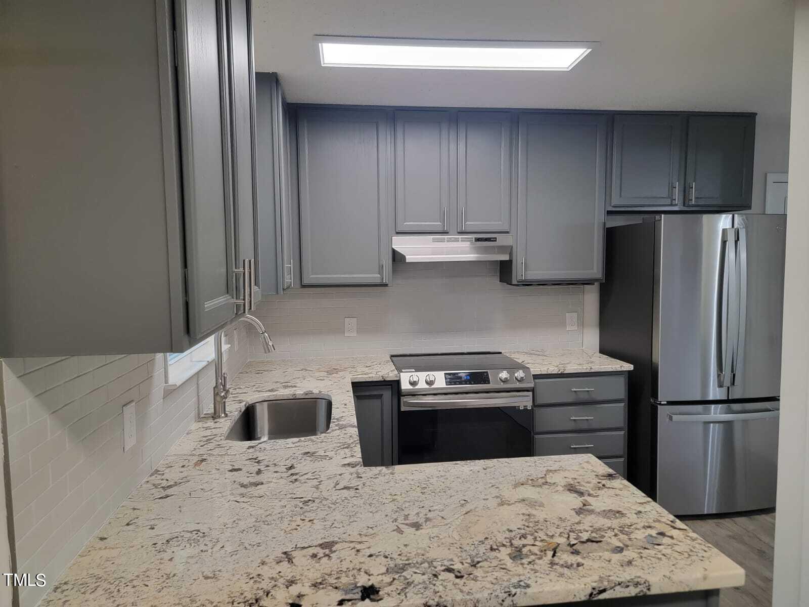 4008 Old Coach Road Raleigh, NC 27616 - Photo 4 of 48 a kitchen with a stove a refrigerator and a sink
