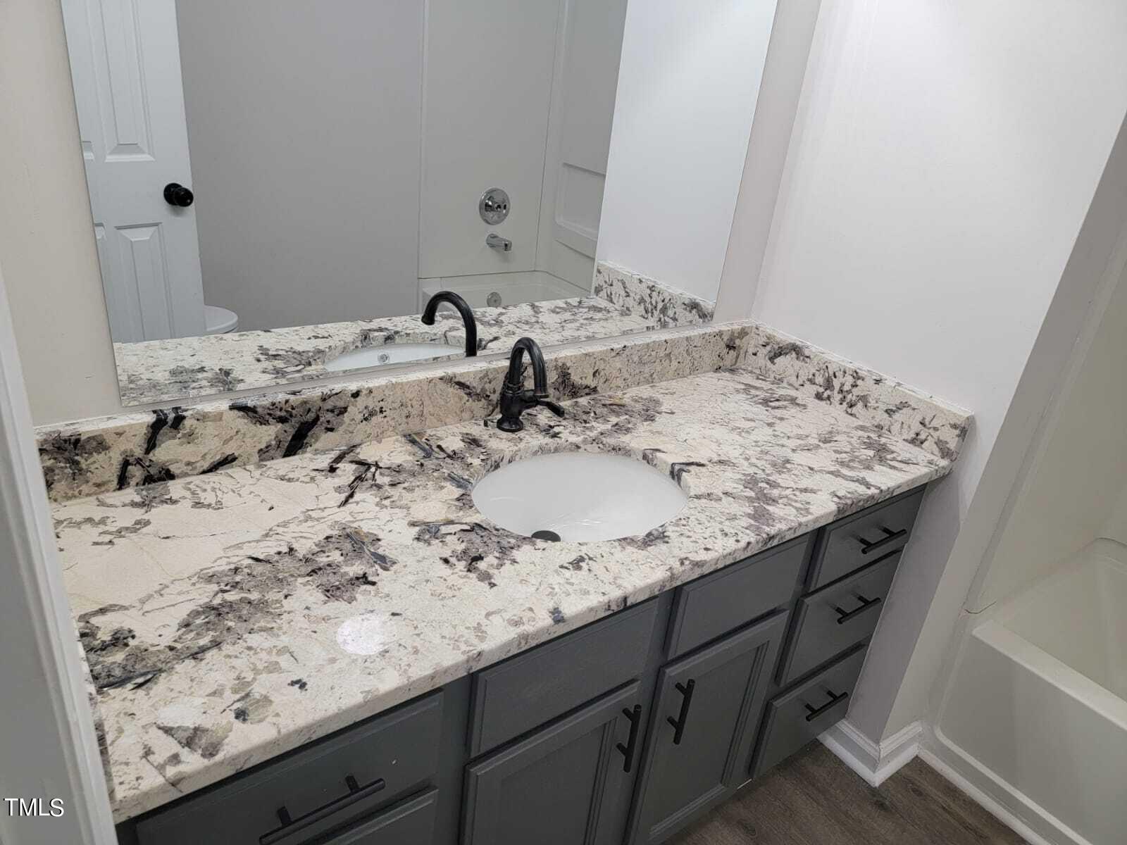 4008 Old Coach Road Raleigh, NC 27616 - Photo 42 of 48 a bathroom with a granite countertop sink and a mirror