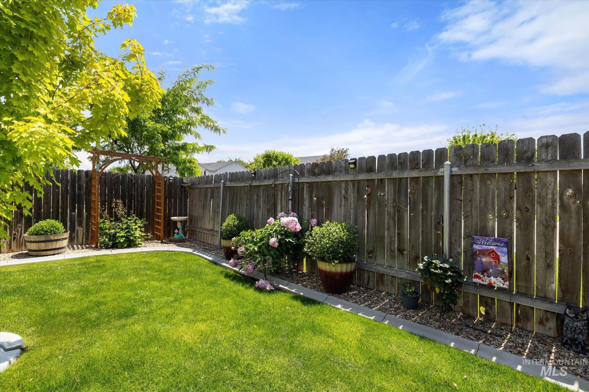 5401 Barkley Way Caldwell, ID 83607 - Photo 32 of 35 Expansive backyard featuring a manicured lawn, a wood privacy fence, and a decorative wood arbor