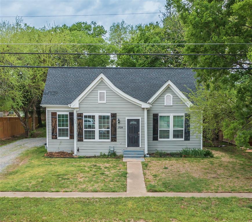 1709 Franklin Street Bonham, TX 75418 - Photo 1 of 1 a view of a white house with a yard plants and large tree