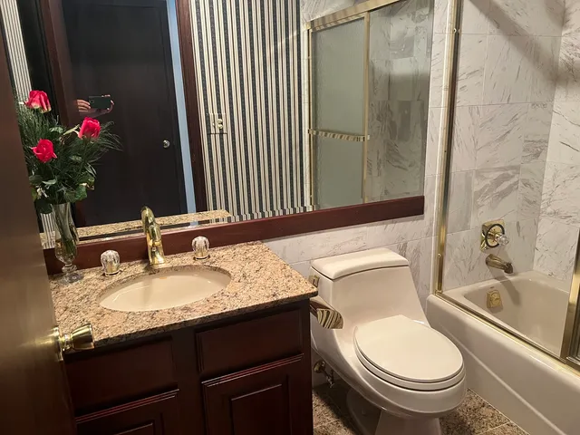 a bathroom with a granite countertop sink toilet and shower