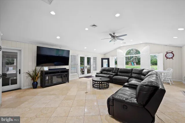 a living room with furniture large window and flat screen tv