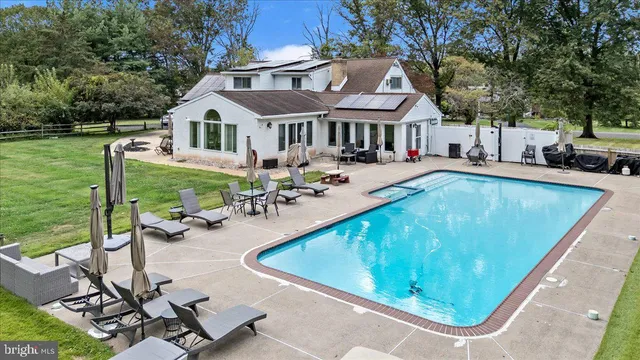 a view of a house with pool and chairs