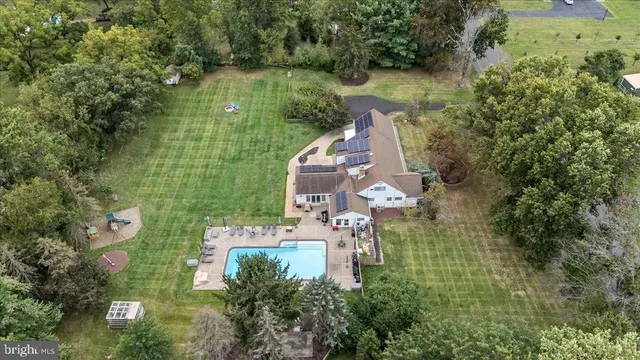 an aerial view of residential houses with outdoor space and trees