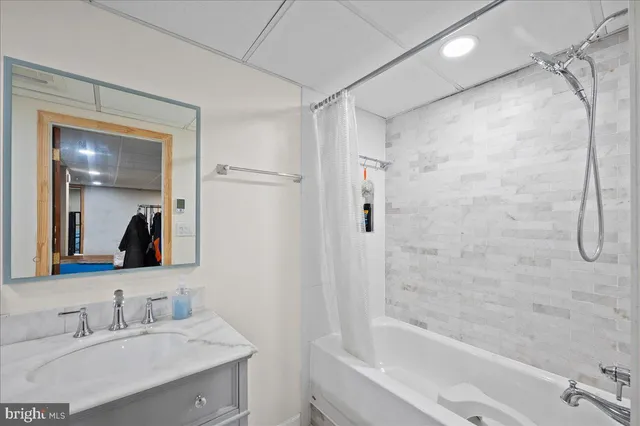 a bathroom with a bathtub shower sink and mirror