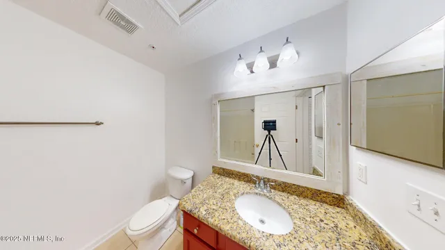 a bathroom with a granite countertop sink toilet mirror vanity and shower