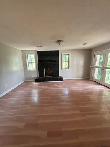 a view of empty room with window and fireplace