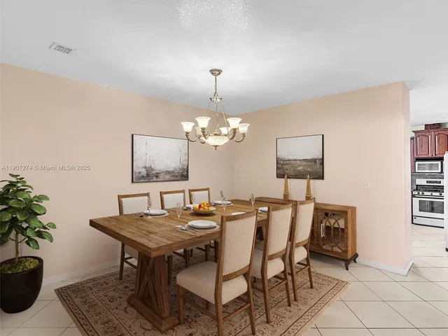 a kitchen with a stove a sink dishwasher a dining table and chairs with wooden floor