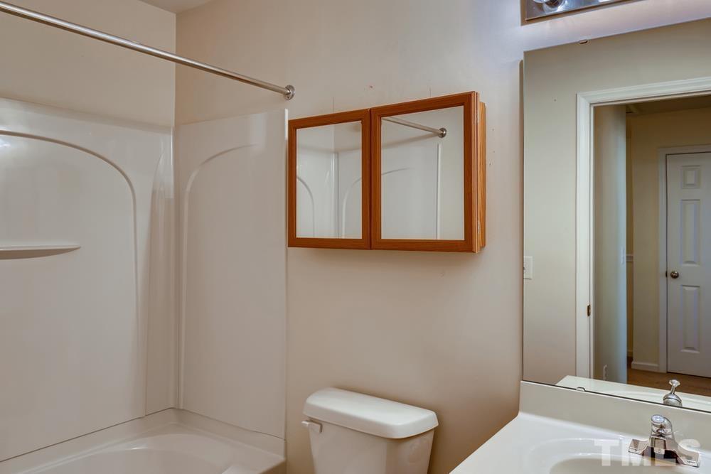 4906 Ravel Stone Court Raleigh, NC 27610 - Photo 23 of 28 a bathroom with a toilet a sink and mirror