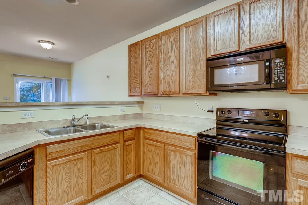 4906 Ravel Stone Court Raleigh, NC 27610 - Photo 9 of 28 a kitchen with granite countertop cabinets stainless steel appliances and a sink