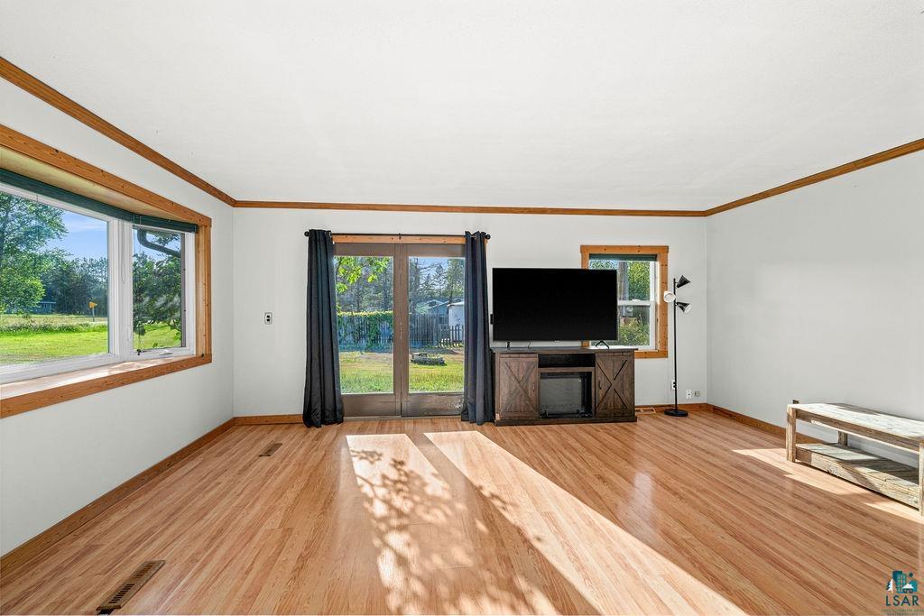 3949 East County Rd B Superior, WI 54880 - Photo 15 of 50 Hardwood flooring, white painted walls, wood-trimmed windows, and double glass panel doors