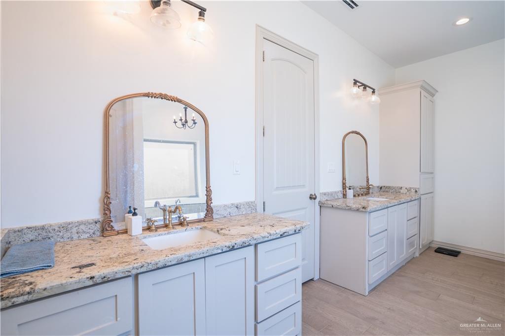 15421 Mile 20 Road Edinburg, TX 78542 - Photo 16 of 24 a bathroom with a granite countertop sink a mirror and shower