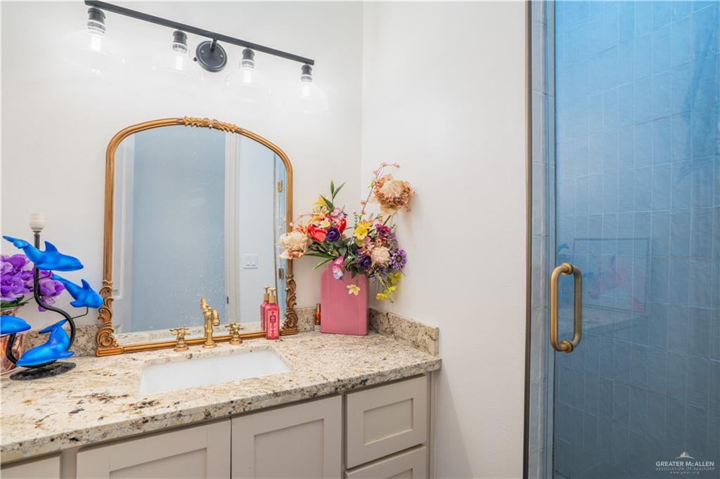 15421 Mile 20 Road Edinburg, TX 78542 - Photo 20 of 24 a bathroom with a granite countertop sink a mirror and shower