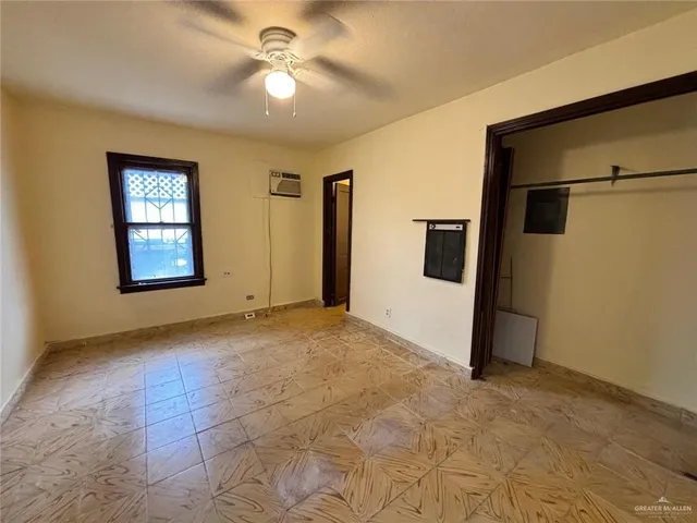 a view of a big room with windows and chandelier fan