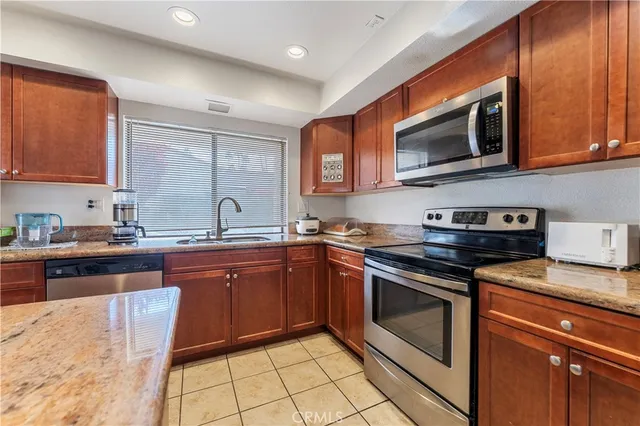 a kitchen with stainless steel appliances granite countertop a stove a sink and a microwave