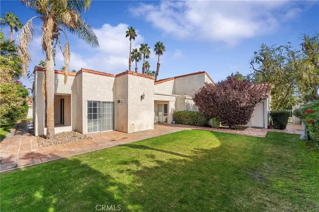a view of a house with a big yard and large tree