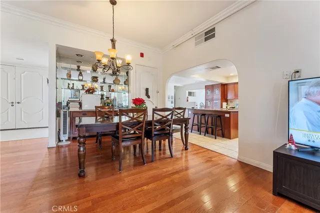a view of a dining room and livingroom with furniture wooden floor a chandelier