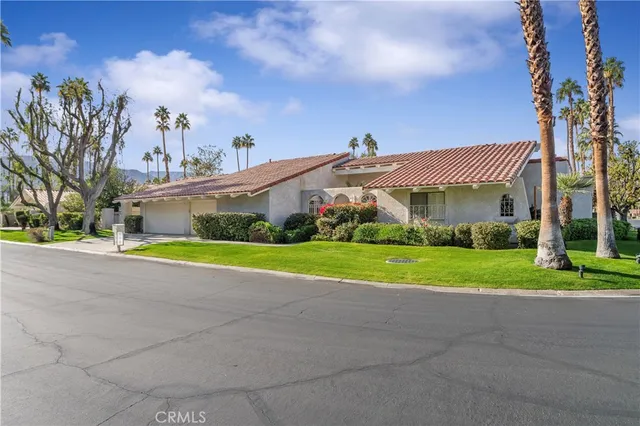 a view of a house with a big yard and large trees