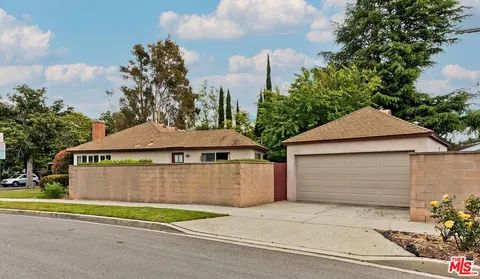 a front view of a house with a garden and garage