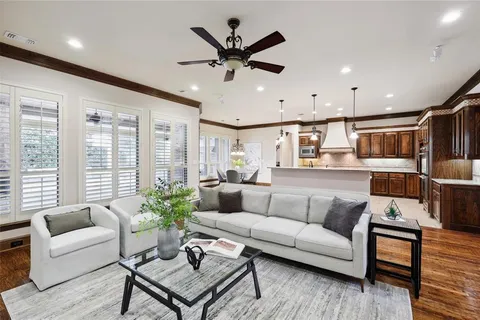 a living room with furniture kitchen view and a large window