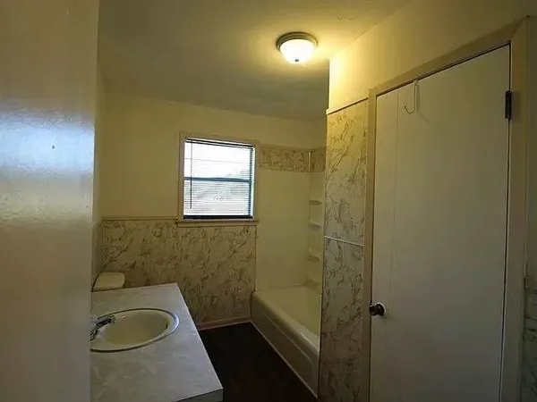 a bathroom with a granite countertop toilet a sink and shower