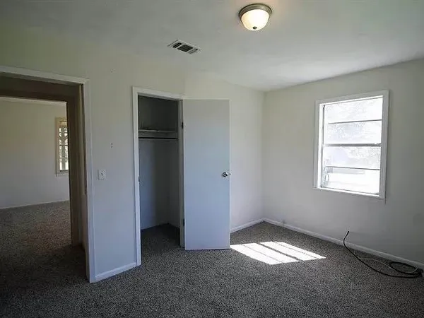 an empty room with windows and closet