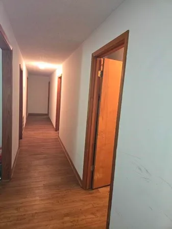 a view of a hallway with wooden floor