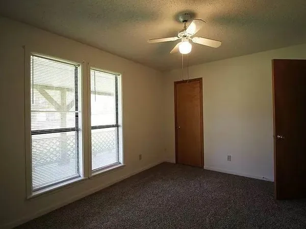 a view of a livingroom with a chandelier fan and a window