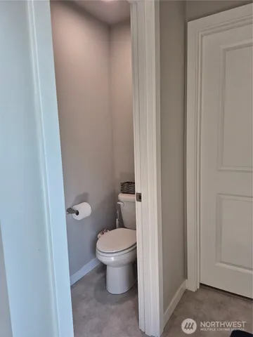 a bathroom with a granite countertop toilet and a sink