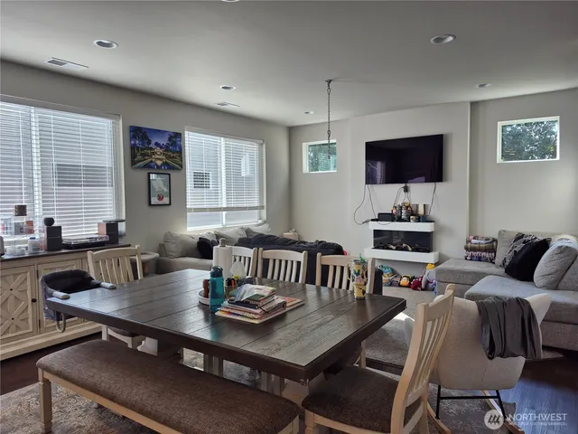 a living room with furniture a flat screen tv and a large window