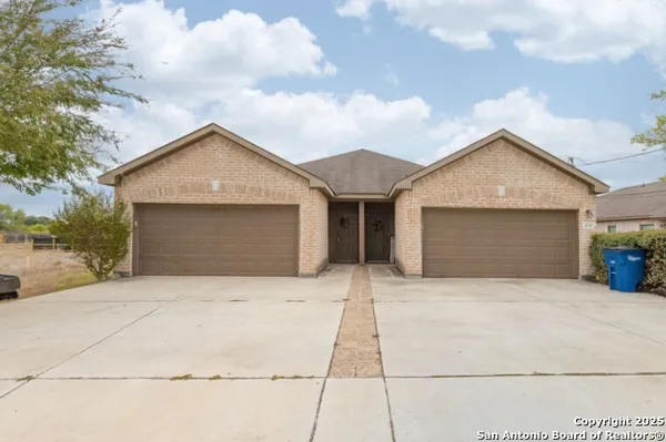 a front view of a house with yard and garage