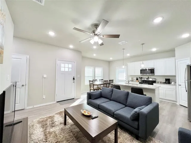 a kitchen with a table chairs microwave and cabinets