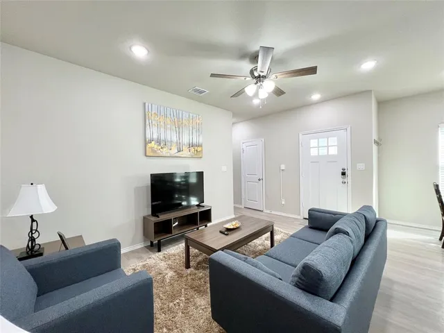 a living room with furniture and kitchen view