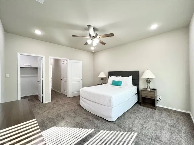 a bedroom with a large bed chandelier and a window