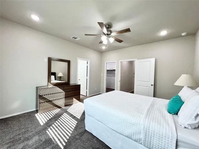 a spacious bedroom with a bed and a chandelier