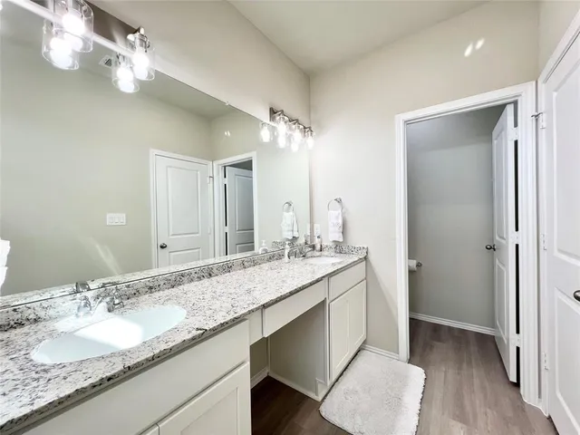 a bathroom with a granite countertop sink a mirror and shower