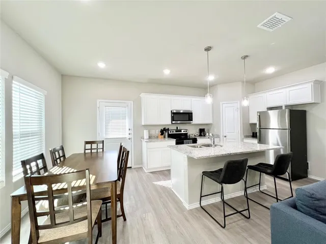 a living room kitchen with furniture and a refrigerator
