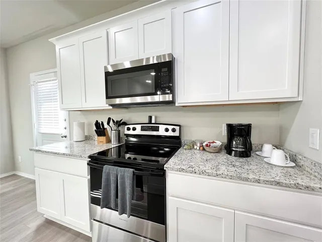 a kitchen with kitchen island white cabinets and refrigerator