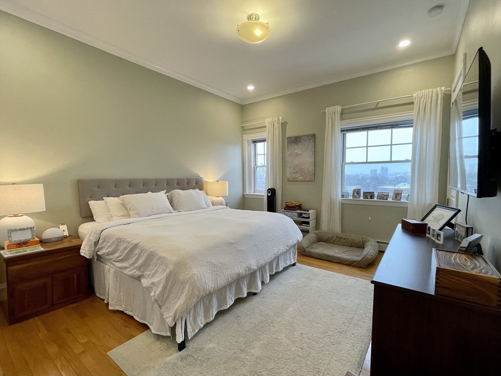 55 Magazine Street, Unit 64 Cambridge, MA 02139 - Photo 6 of 23 a spacious bedroom with a bed and a flat screen television