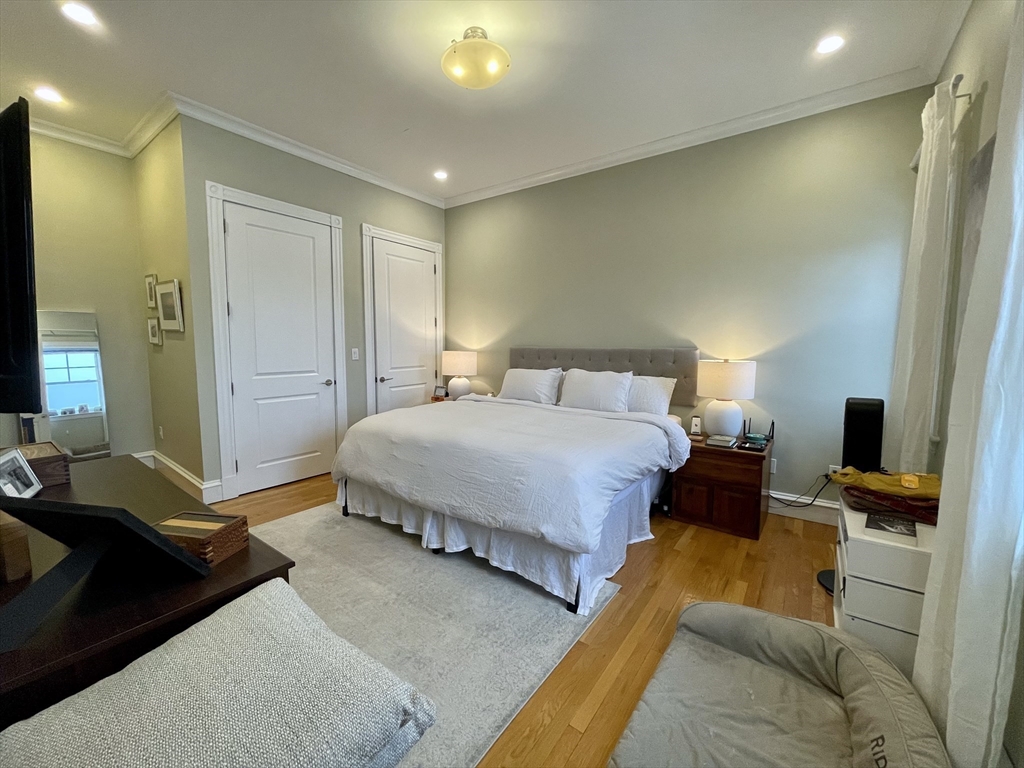 55 Magazine Street, Unit 64 Cambridge, MA 02139 - Photo 7 of 23 a bedroom with a bed and wooden floor