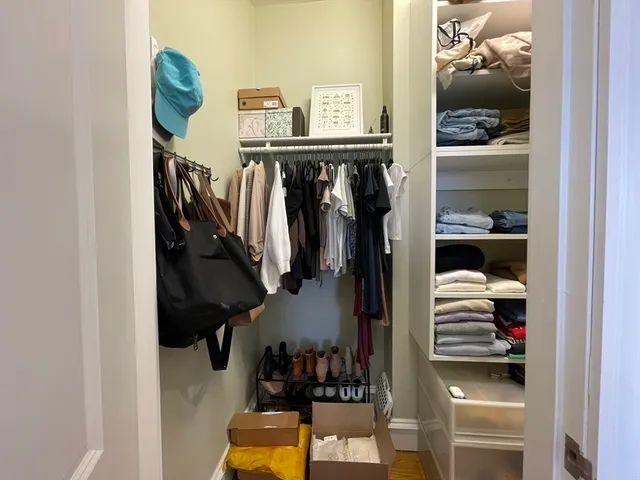 a view of walk in closet with clothes and shoes