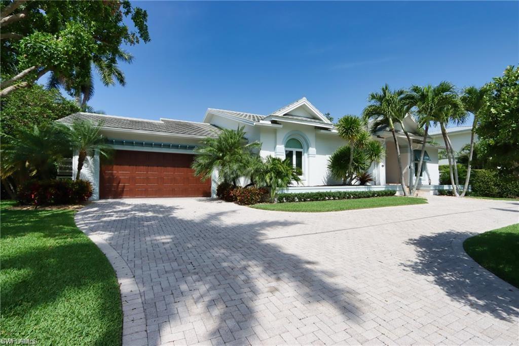 a front view of a house with a yard and potted plants