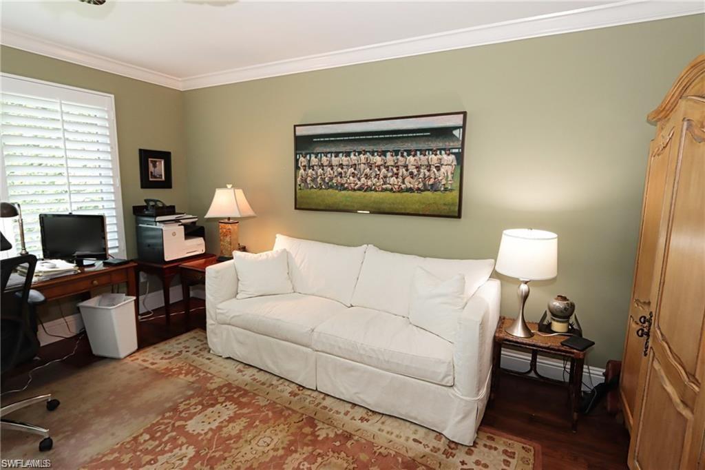 2201 Beacon Lane Naples, FL 34103 - Photo 14 of 34 a living room with furniture a lamp and a flat screen tv
