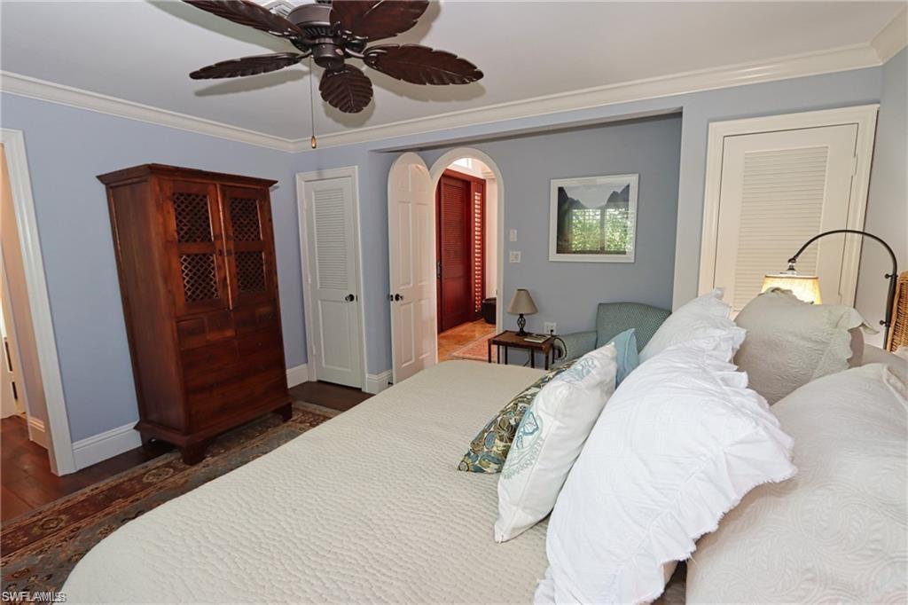 2201 Beacon Lane Naples, FL 34103 - Photo 20 of 34 a bedroom with a large bed and a chandelier