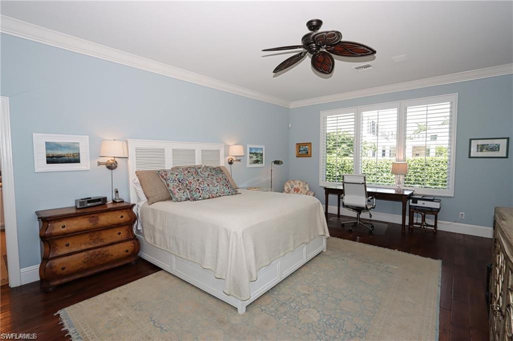 2201 Beacon Lane Naples, FL 34103 - Photo 23 of 34 a bedroom with a bed and a chandelier