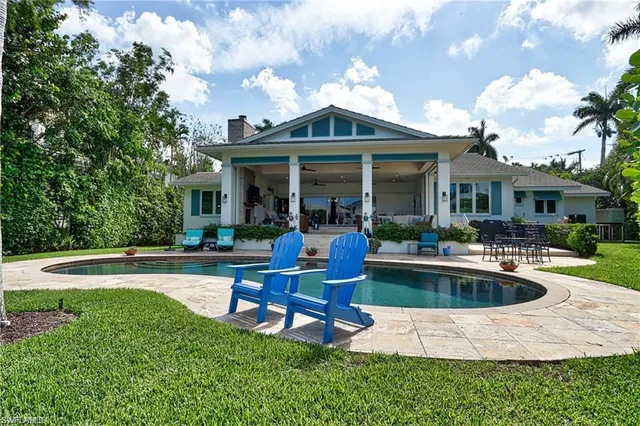 a view of a house with swimming pool and sitting area